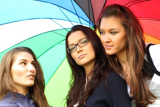 girlfriends stay under colourful umbrella 