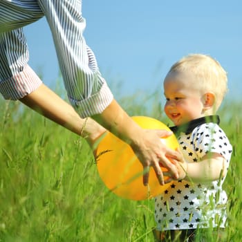  little boy play in green grass with yellow ball
