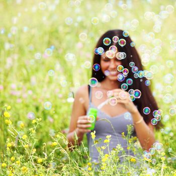  happy woman smile in green grass soap bubbles around