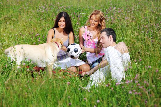 friends and dog in green grass field