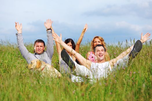 friends and dog in green grass field