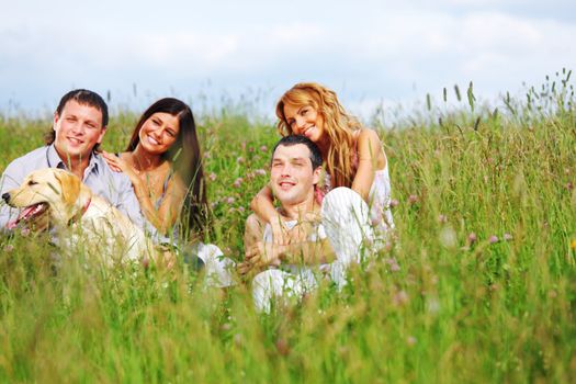 friends and dog in green grass field