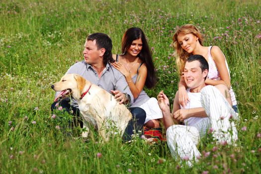 friends and dog in green grass field