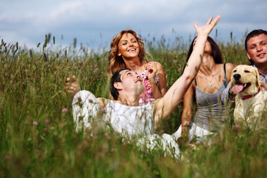 friends and dog in green grass field