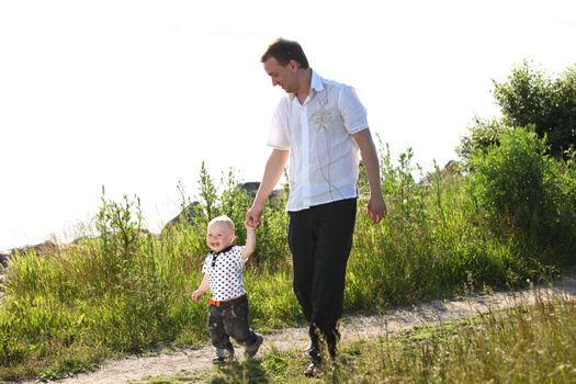 father and son walking on grass