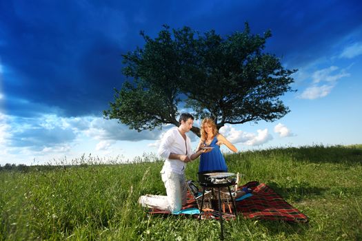 man and woman on picnic in green grass
