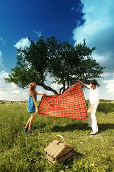 man and woman on picnic in green grass