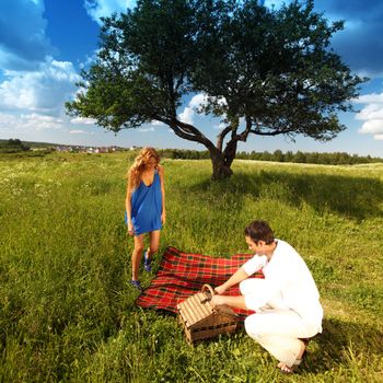 man and woman on picnic in green grass