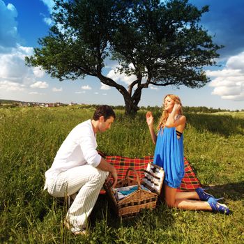 man and woman on picnic in green grass