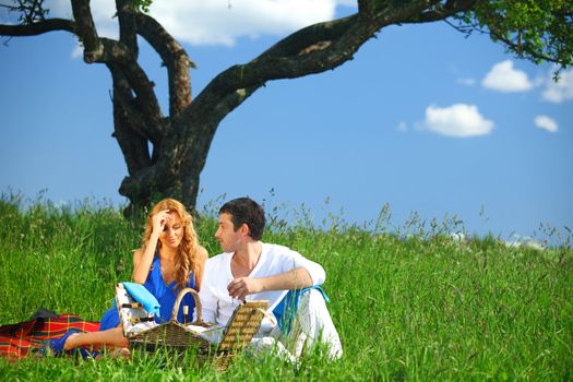 man and woman on picnic in green grass