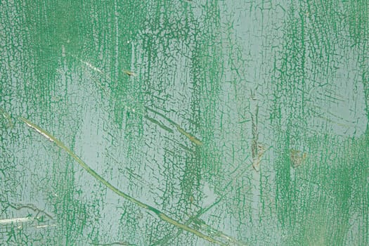 An old surface with worn layers of green paint forming a variety of textures.