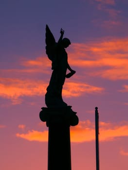 Warrnambool, Australia - August 16, 2005: The Warrnambool War Memorial commemorates Australian veterans who served their country.  Seen here is the angel on the top part of the monument silhouetted against the sunset.