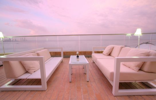 Stunning view of outdoor chairs and a couch to enjoy the sunset of the beach