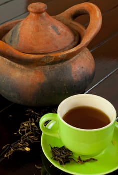 green cup of hot tea on wood background