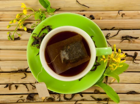 green cup of hot tea on wood background