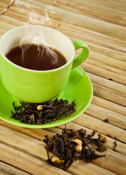 green cup of hot tea on wood background