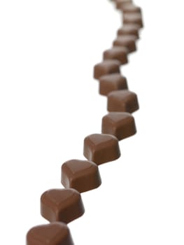 Heart shaped chocolate in a row on white background