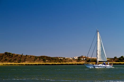 View of a sailboat in the Guadiana river in the Algarve, Portugal.