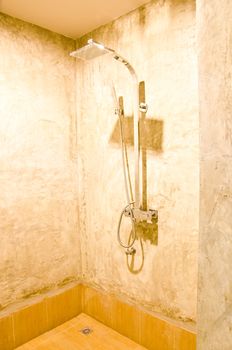 Shower in bathroom with polished concrete walls. Home interiors.