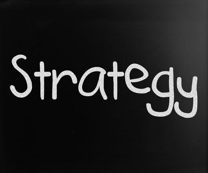 "Strategy" handwritten with white chalk on a blackboard