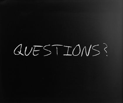 "Questions?" handwritten with white chalk on a blackboard.