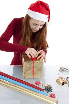 young woman is packing  present for christmas isolated on white