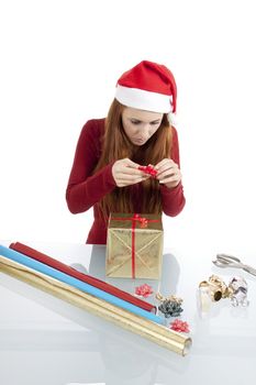 young woman is packing  present for christmas isolated on white