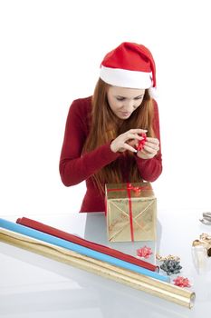 young woman is packing  present for christmas isolated on white