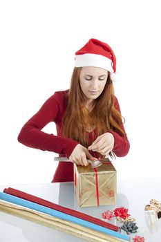 young woman is packing  present for christmas isolated on white