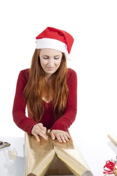 young woman is packing  present for christmas isolated on white