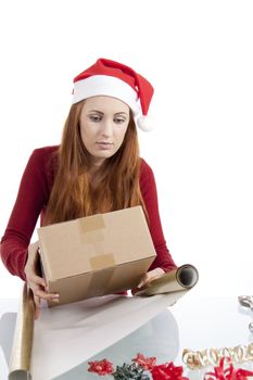 young woman is packing  present for christmas isolated on white