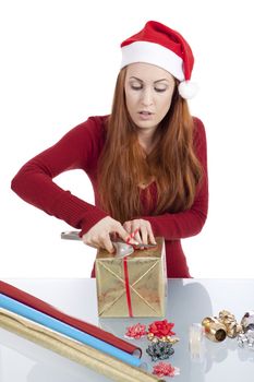 young woman is packing  present for christmas isolated on white