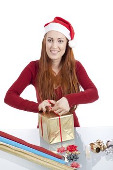 young woman is packing  present for christmas isolated on white