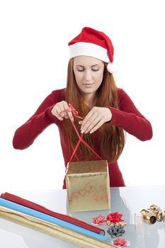 young woman is packing  present for christmas isolated on white