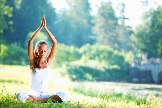 yoga woman on green grass in lotus pose