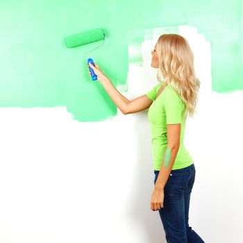 woman paints the wall brush