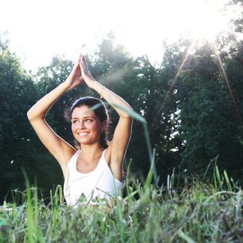 yoga woman on green grass lotus pose in sunrise light