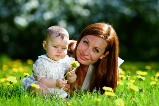 Happy mother and daughter on the green grass