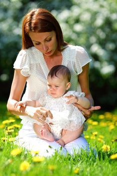 Happy mother and daughter on the green grass