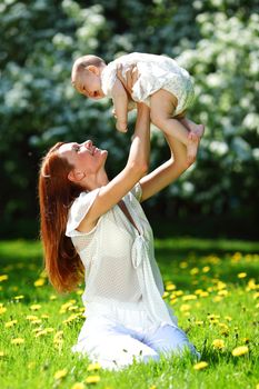 Happy mother and daughter on the green grass