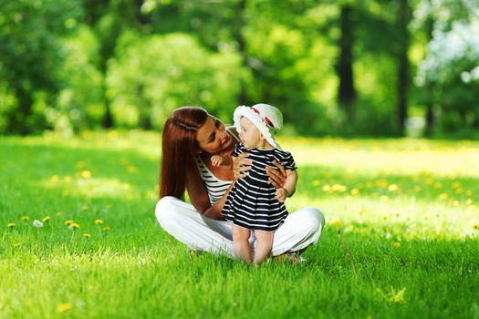 Happy mother and daughter on the green grass