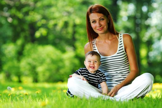 Happy mother and daughter on the green grass
