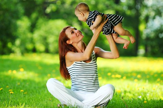 Happy mother and daughter on the green grass
