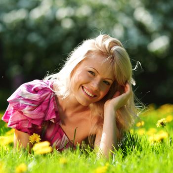  girl lying on the field of dandelions