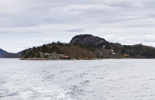 landscape in norway - coastline in fjord with buildings