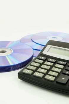 Office supplies, calculator, compact discs on white desk