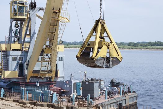 Floating crane, working on strengthening the riverside