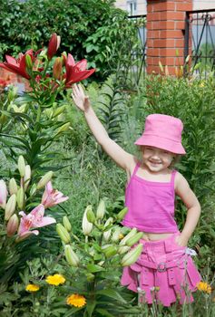 Baby girl in the pink dress in the garden
