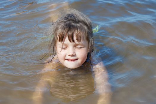 Baby girl swimming in the river in summer