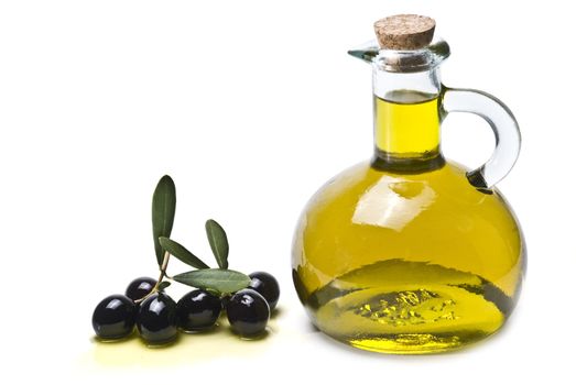 A jar with olive oil and some black olives isolated over a white background.
